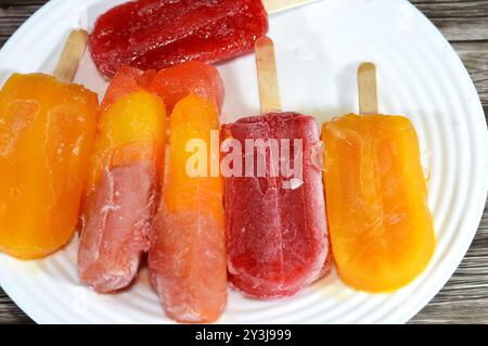 Eisbars aus echten Früchten von Mango und gemischten Beeren, eine Eisbar ist ein gefrorenes Dessert mit Eis auf einem Stock, Sommer und Urlaub Stockfoto