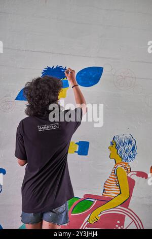Junger Straßenkünstler Malerei an der Wand, Straßenkunst im öffentlichen Bereich der Stadt - Jakarta, Indonesien: 16. Juni 2022 Stockfoto