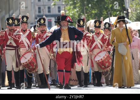 Bath, UK. September 2024. Die Grand Regency Parade ist der Beginn des jährlichen Jane Austen Festivals in Bath. Das jährliche Festival zieht Austen-Enthusiasten aus aller Welt an, die Prozession von rund 500 Menschen in Kostümen ist der Beginn einer Woche von Austen inspirierten Veranstaltungen. Vom Holbourne Museum aus führt die Prozession durch historische Straßen, die sich seit Austens Zeit kaum verändert haben. Quelle: JMF News/Alamy Live News Stockfoto