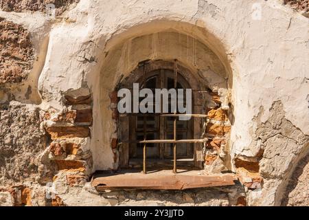 Kleines Fenster in der Steinmauer eines mittelalterlichen Gebäudes Stockfoto