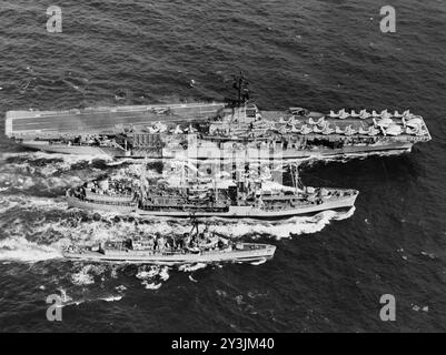 Der US-amerikanische U-Boot-Flugzeugträger USS Hornet (CVS-12) und der Zerstörer USS Nicholas (DD-449), während der Auffüllung des Flottenölers USS Cimarron (AO-22) vor der Küste Nordvietnams um 1966 Stockfoto