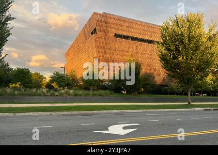 Ein großes Gebäude mit vielen Fenstern und vielen Bäumen im Hintergrund. Das Gebäude ist orange und gelb. Washington, D.C. USA Stockfoto