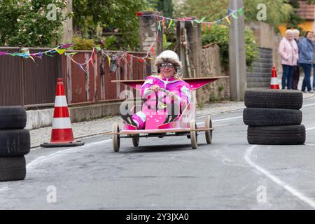 Zschaiten, Deutschland. September 2024. Beim Seifenboxen-Rennen im sächsischen Zschaiten wetteifern die Teilnehmer mit ihren skurrilen Kostümen und Fahrzeugen um die beste Zeit. Die kleine Gemeinde bei Riesa feiert am 13-15. September 2024 ihr 700-jähriges Bestehen. Darlegung: Daniel Wagner/dpa/Alamy Live News Stockfoto