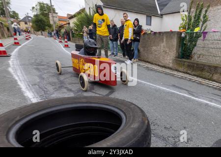 Zschaiten, Deutschland. September 2024. Beim Seifenboxen-Rennen im sächsischen Zschaiten wetteifern die Teilnehmer mit ihren skurrilen Kostümen und Fahrzeugen um die beste Zeit. Die kleine Gemeinde bei Riesa feiert am 13-15. September 2024 ihr 700-jähriges Bestehen. Darlegung: Daniel Wagner/dpa/Alamy Live News Stockfoto