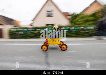 Zschaiten, Deutschland. September 2024. Ein Mann sitzt in einer Blechwanne beim Seifenboxen-Rennen im sächsischen Zschaiten, bei dem die Teilnehmer mit ihren bizarren Kostümen und Fahrzeugen um die beste Zeit kämpfen. Die kleine Gemeinde bei Riesa feiert am 13-15. September 2024 ihr 700-jähriges Bestehen. Darlegung: Daniel Wagner/dpa/Alamy Live News Stockfoto