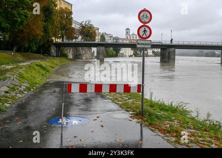 Passau, Deutschland. September 2024. Am überfluteten Ufer des Gasthauses steht eine Barriere. Auch wenn der meiste Regen am Wochenende in Bayern wahrscheinlich schon gefallen ist, wird sich der Niederschlag erst Stunden oder Tage später an den Flüssen bemerkbar machen. In Passau, wo drei Flüsse aufeinander treffen, sollte nach Angaben der Stadt in den Abendstunden mit den ersten Schließungen in der Altstadt gerechnet werden. Quelle: Armin Weigel/dpa/Alamy Live News Stockfoto