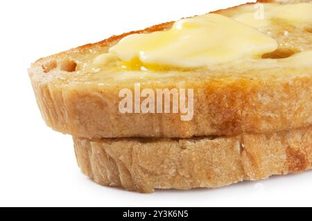 Studio-Aufnahme von Butter, die auf Scheiben Sauerteigbrot schmilzt, die vor weißem Hintergrund ausgeschnitten wurden - John Gollop Stockfoto