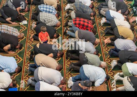 Dearborn, Michigan - Ein kleiner Junge hält sich während der Freitagsgebete in der Nähe seines Vaters im Islamischen Zentrum von Amerika, der größten Moschee Nordamerikas. Stockfoto