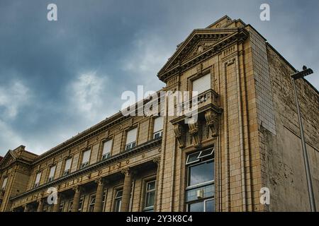 Aus nächster Nähe sehen Sie ein kunstvolles historisches Gebäude mit komplexen architektonischen Details, mit dekorativen Säulen und einem markanten Gesims gegen A Stockfoto