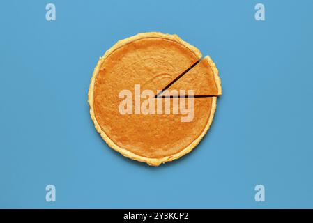 Blick von oben mit einem hausgemachten Kürbiskuchen Minimalist auf einem blauen Tisch Stockfoto