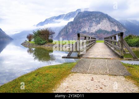 Spätherbst-Alpenlandschaft mit dem Dachsteingebirge, dem Hallstatter See und einer Holzbrücke zur kleinen Seeinsel in Hallstätter Stadt, Stockfoto