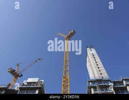 Ein Blick auf hohe Turmkräne, die auf großen Baustellen vor einem blauen Himmel in leeds england arbeiten Stockfoto