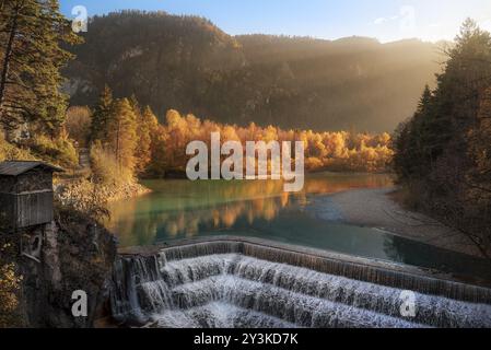 Bezaubernde Herbstlandschaft mit einer alten Hütte, der Treppe des Lechfall-Wasserfalls, dem Fluss Lech und einem Herbstwald in Füssen, Deutschland, Europa Stockfoto