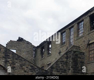 Ein altes, verlassenes großes Industriebau mit ausgebrannten Fenstern und einfallenden Wänden Stockfoto