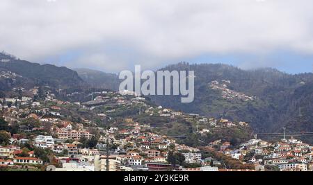 Ein breites Panoramablick auf die Stadt funchal auf Madeira mit Gebäuden der Stadt vor den Bergen, die von W bedeckt sind Stockfoto