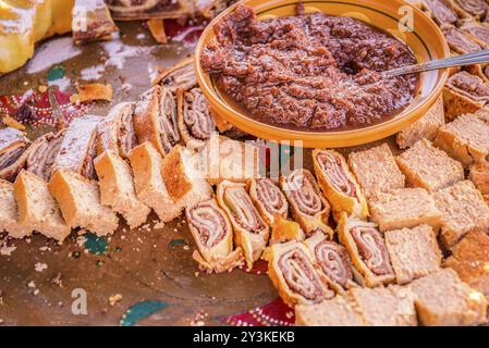 Großer Teller voller slowenischer Süßigkeiten und leckerer Kuchen aus der Region Zasip, basierend auf getrocknetem Birnenpulver und einer Schüssel Birnenmarmelade Stockfoto