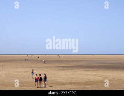 Southport, merseyside, vereinigtes Königreich, 28. juni 2019: Eine Gruppe junger Frauen, die an einem hellen Sommertag auf den langen Strand von formby in der Nähe von southport spazieren Stockfoto