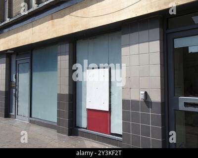 Verlassene, geschlossene Hausbank oder Ladenfront mit vertauften und überdachten Fenstern Stockfoto