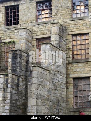Ein großes, verfallenes, verlassenes Fabrikgebäude mit verschlossenen und kaputten Fenstern Stockfoto