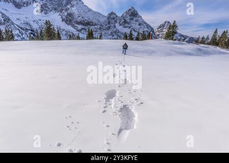 Winterlandschaft mit einem Mann zu Fuß durch Schnee auf einer Bergspitze, lässt eine Spur der Schritte hinter ihm. Bild auf österreichischen Alpen, in der Nähe von Ehrwa Stockfoto