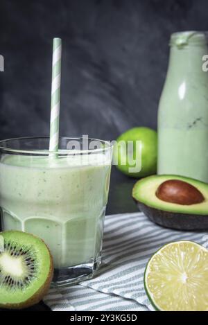 Glas mit grünem Smoothie und frischem Obst auf einem Küchentisch. Gesunde Ernährung. Detox-Konzept. Vegetarische Speisen. Diätkonzept Stockfoto
