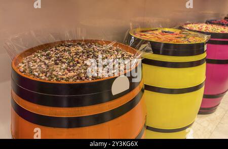 Lustig aussehende Süßigkeiten, Schokoladenbonbons in Form und Farbe als Steine, auf Holzfässern platziert Stockfoto