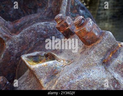 Eine Nahaufnahme von Achsbolzen und Rad an alten verrosteten, verlassenen Industriemaschinen Stockfoto