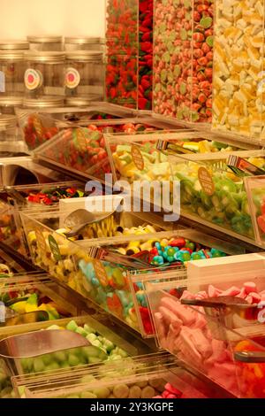 Bunte Gelee-Bonbons werden auf dem Markt in Regalboxen aus Glas gestapelt Stockfoto