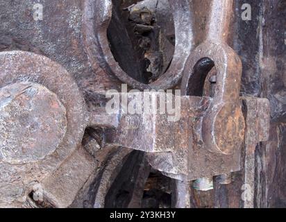Nahaufnahme von Pleuelstangen und Zahnrädern aus rostfreiem Eisen mit Schrauben an alten korrodierten Maschinen Stockfoto