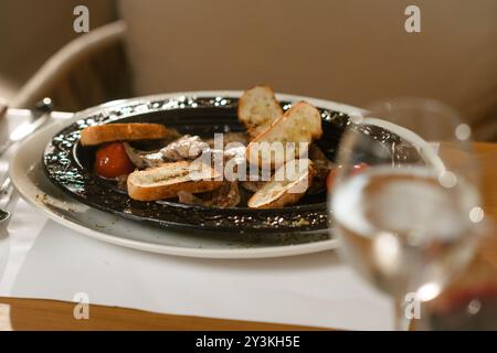 Zarte Lammkoteletts, serviert mit Kräutertoast, gegrillten Tomaten und einer reichhaltigen Sauce. Eine herzhafte und geschmackvolle Mahlzeit für Fleischliebhaber Stockfoto