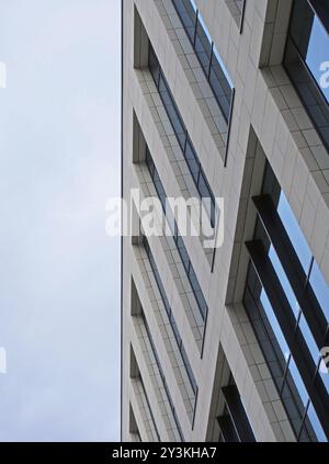 Schräge Nahaufnahme eines modernen Bürogebäudes mit blauem bewölktem Himmel Stockfoto