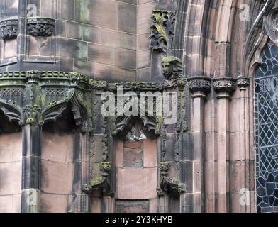Details von kunstvoll geschnitzten mittelalterlichen Steinmetzarbeiten mit Nischen und Gesichtern an der Fassade der Kathedrale von chester Stockfoto