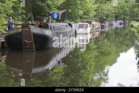 Hebden Bridge, West yorkshire, vereinigtes Königreich, 12. juli 2019: Eine Frau neben schmalen Booten und Lastkähnen vertäut am rochdale-Kanal in hebden Bridge sur Stockfoto