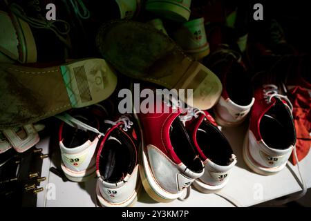 Alte gebrauchte Bowlingschuhe auf einem Stapel. Verschiedene Größen Stockfoto