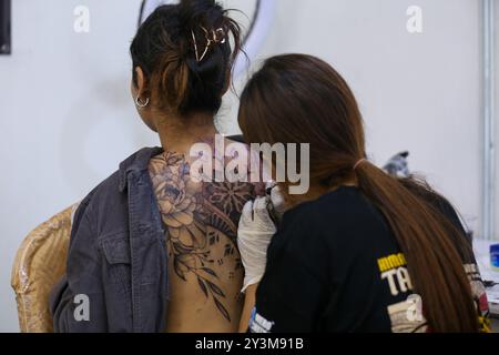 Lalitpur, Nepal. September 2024. Ein Künstler (R) färbt ein Tattoo auf den Körper eines Enthusiasten (L) während der Himalaya Tattoo Convention in Lalitpur, Nepal, am 14. August 2024. Der von der National Academy of Fine Arts und der Nepal Handicraft Association unterstützte Tattoo Summit zeigt mehr als vier Dutzend Künstler, die Götterbilder mit modernen Konzepten einfärben. (Foto: Subaas Shrestha/NurPhoto) Credit: NurPhoto SRL/Alamy Live News Stockfoto