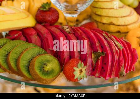 Exquisite Auswahl an frisch geschnittenen tropischen Früchten, die elegant auf einer Glasplatte präsentiert werden. Stockfoto