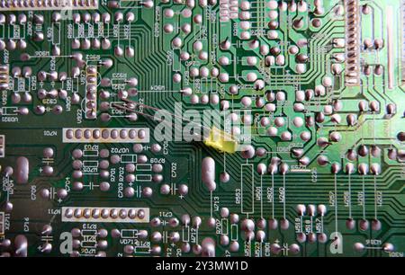 Eine gelbe LED auf der gelöteten Schicht einer elektronischen Leiterplatte. Stockfoto