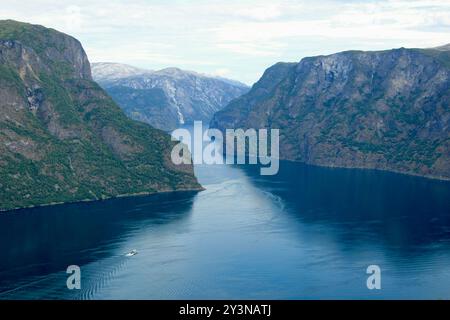 Blick auf Nærøyfjord in Norwegen mit einem Boot, das durch seine ruhigen Gewässer fährt Stockfoto