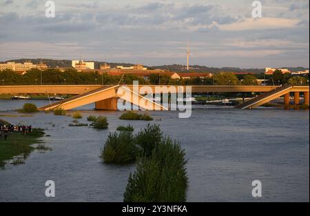 Dresden, Deutschland. September 2024. Das Wasser aus der Elbe fließt abends über Teile der eingestürzten Carola Brücke. Die Abriss- und Rodungsarbeiten an der teilweise eingestürzten Dresdner Carola-Brücke sollten auf der Neustädter Seite bis zum Abend abgeschlossen sein. Robert Michael/dpa/Alamy Live News Stockfoto