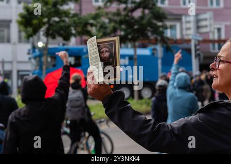 Zürich Oerlikon, Schweiz. September 2024. Ein Teilnehmer des "Marsches um das Leben" betet vor einer Gruppe von Gegendemonstratoren. Der „Marsch fürs Läbe“ ist eine jährliche Veranstaltung, die sich gegen Abtreibung richtet und sich für die Rechte des Ungeborenen einsetzt. Quelle: Fabienne Koch/Alamy Live News. Stockfoto