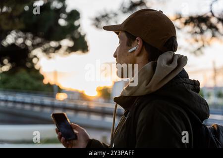 Ein Mann, der durch die Stadt läuft und Musik mit Kopfhörern hört Stockfoto