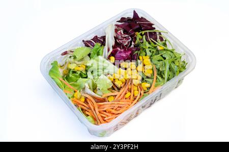 Plastikbox voller gemischter frischer Gemüsesalat mit Mais, Rucola, Karotten usw. Stockfoto
