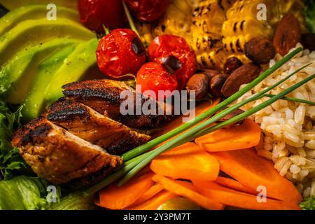 Buddha Schüssel mit Reis, gebackenem Schweinefleisch und Gemüse. Schüssel mit gesundem Salat mit Avocado, Karotten, Mais. Konzept für gesunde Ernährung. Nahaufnahme. Hintergrund. H Stockfoto