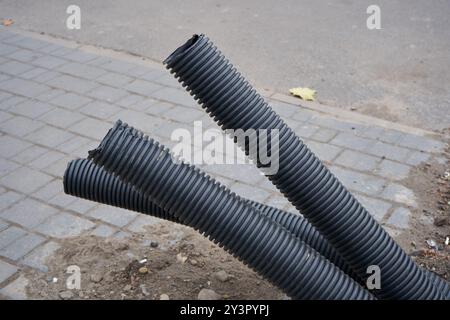 Unfertige Konstruktion von unterirdischen Wellrohren, unverschüttete Rohre liegen Stockfoto