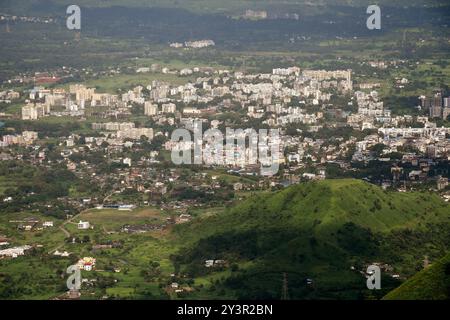 Ein allgemeiner Blick auf die Stadt Neral unterhalb der Bergstation Matheran im Bezirk Raigad am Stadtrand von Mumbai. Matheran ist eine wunderschöne Bergstation am Stadtrand im Raigad Bezirk von Maharashtra. In der Bergstation sind Kraftfahrzeuge verboten, und Touristen können einen Spielzeugzug nehmen, der direkt in die Bergstation fährt, von wo aus sie entweder zu Fuß gehen oder eine handgezogene Rikscha mieten oder auf einem Pferd für Besichtigungen in und um die Bergstation fahren können. Die Monsunmonate werden von Touristen bevorzugt, da die gesamte Bergstation durch Regen zu einem grünen Teppich wird. Stockfoto