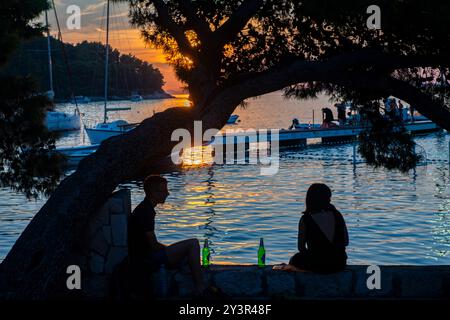 Sitzen Sie unter einem Baum und genießen Sie ein Bier bei Sonnenuntergang in Cavtat, Kroatien Stockfoto