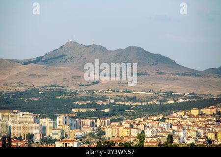 Ein weitläufiges Stadtbild, umgeben von sanften Hügeln und einem entfernten Gipfel, nahe Ankara. Eine malerische Landschaft mit einer modernen Stadt und einem prominenten berg Stockfoto