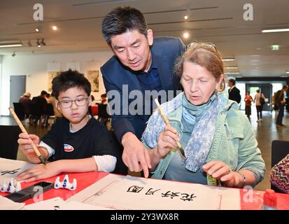 Berlin, Deutschland. September 2024. Eine Frau schreibt chinesische Kalligraphie während einer Feier des bevorstehenden Herbstfestes im Chinesischen Kulturzentrum in Berlin, Deutschland, 14. September 2024. Quelle: Ren Pengfei/Xinhua/Alamy Live News Stockfoto