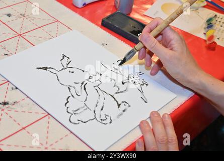 Berlin, Deutschland. September 2024. Eine Frau zeichnet ein Bild während einer Feier des bevorstehenden Herbstfestes im Chinesischen Kulturzentrum in Berlin, 14. September 2024. Quelle: Ren Pengfei/Xinhua/Alamy Live News Stockfoto