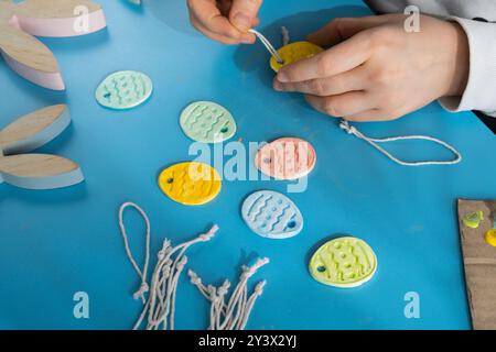 Der Schöpfer verwendet weißen, luftgetrockneten Ton für die Gestaltung der OSTERFERIEN. Erstellen von Freizeitaktivitäten für Hobby mit Fingern. DIY-Herstellung moderner Kunst Stockfoto